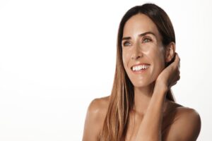Woman smiles widely, showing her revitalized skin after non-surgical skin tightening