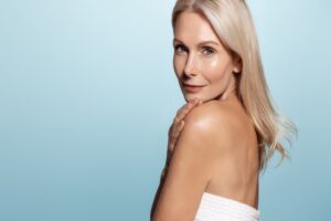 Beautiful woman in her 60s, showing her glowing skin after skin imaging and premium skincare